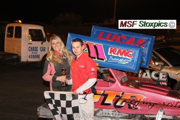 With the trophy and the chequered flag.